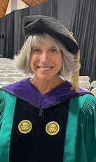 A woman in a graduation gown and cap