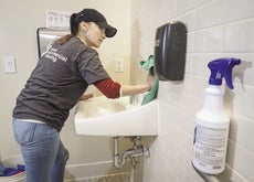 A woman cleans a bathroom.