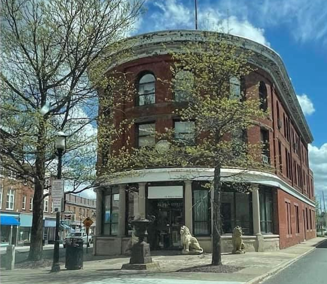A building in downtown Gardner with two lion statues outside