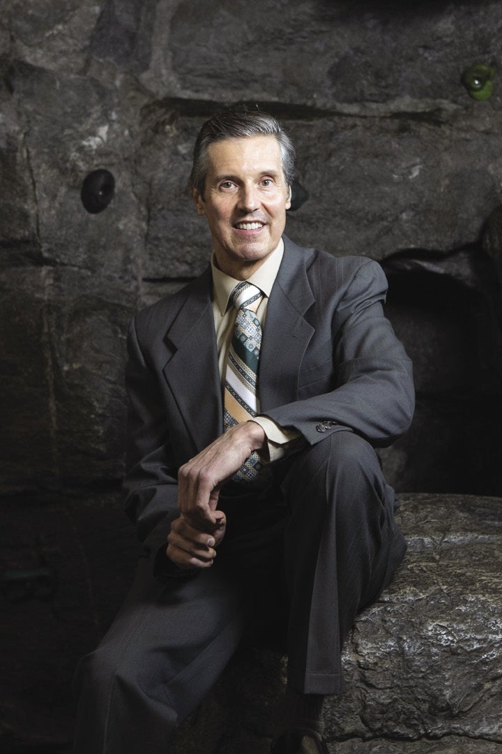 Victor Champagne sits in front of a dark backdrop. 