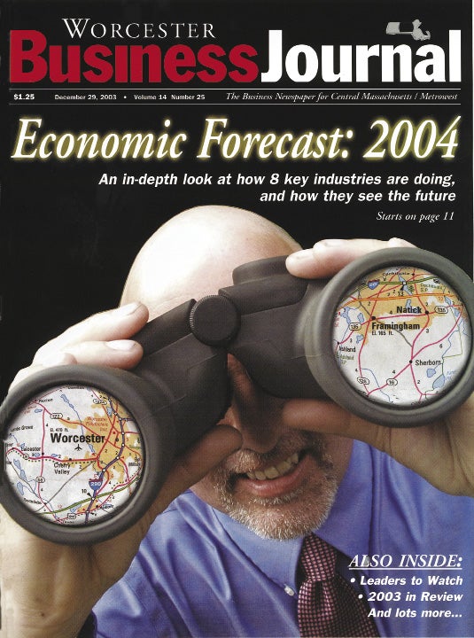 A magazine cover featuring a man in business attire looking through binoculars with maps imprinted on the lenses.