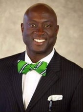A man in a suit and green bowtie
