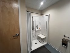 A walk in shower with a seat in a bathroom