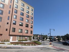 An apartment building next to a busy street