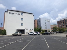 Two hotel buildings side-by-side with a parking lot in front