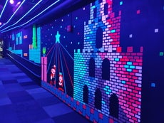 A neon mural of Super Mario characters and settings