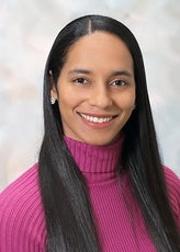 A woman with long, straight black hair wears a magenta knit turtleneck.