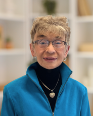 A woman in a blue coat smiles