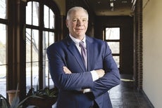 A man wearing a blue suit with a purple tie