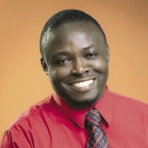 A man in a red shirt and black, purple, and orange patterned tie