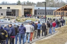 A long line of people waiting outside a building