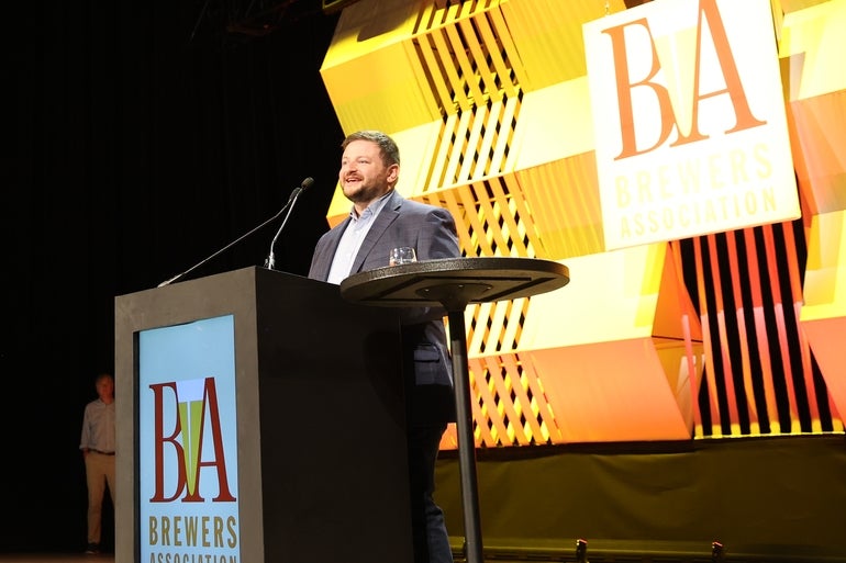 A man stands at a podium in a suit