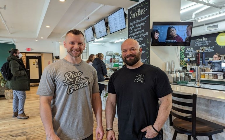 Two men stand in a cafe setting