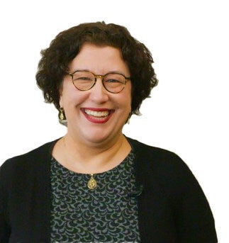 A woman stands in front of a white background