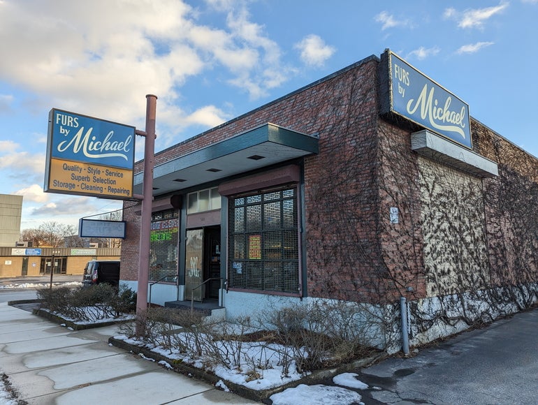 A small one-story building with a sign out front