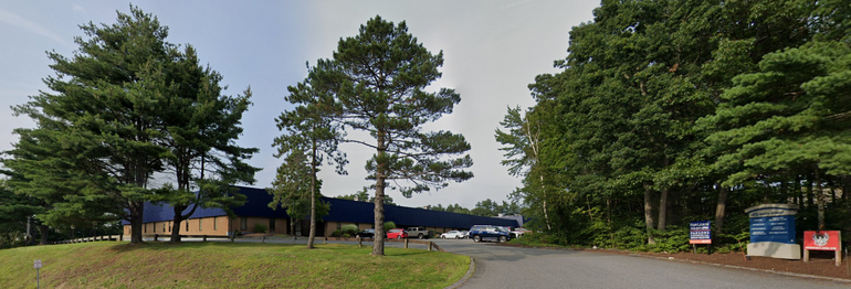 A building with a blue top stands among trees