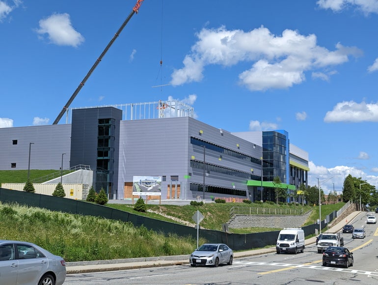 Cars driving past a building under construction