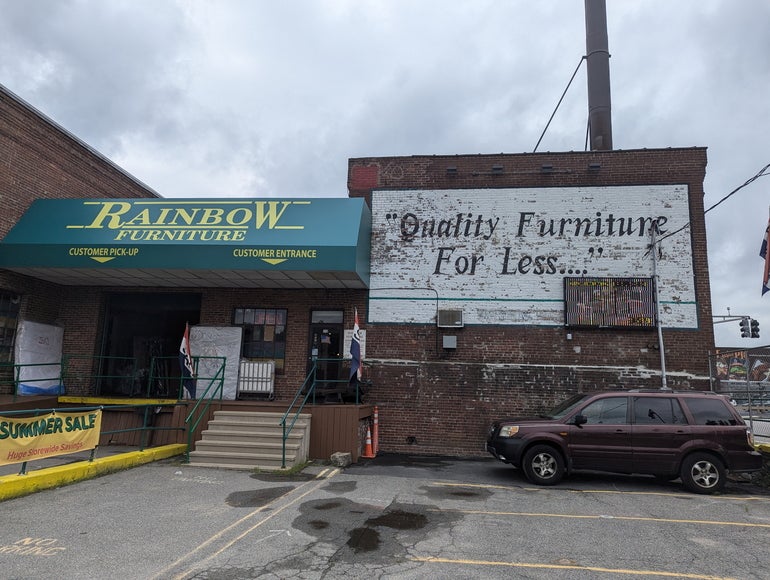 the entrance of a furniture store in a brick building