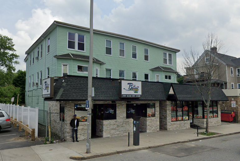 A mixed-use, three-story building with a restaurant on the ground floor and apartments above. 