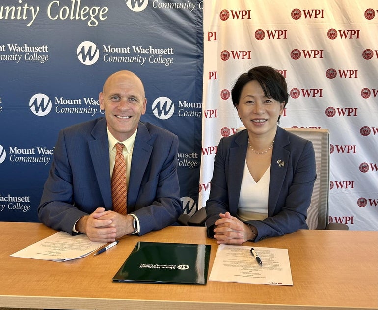 A man and a women in business attire sitting at a table with papers in front of them