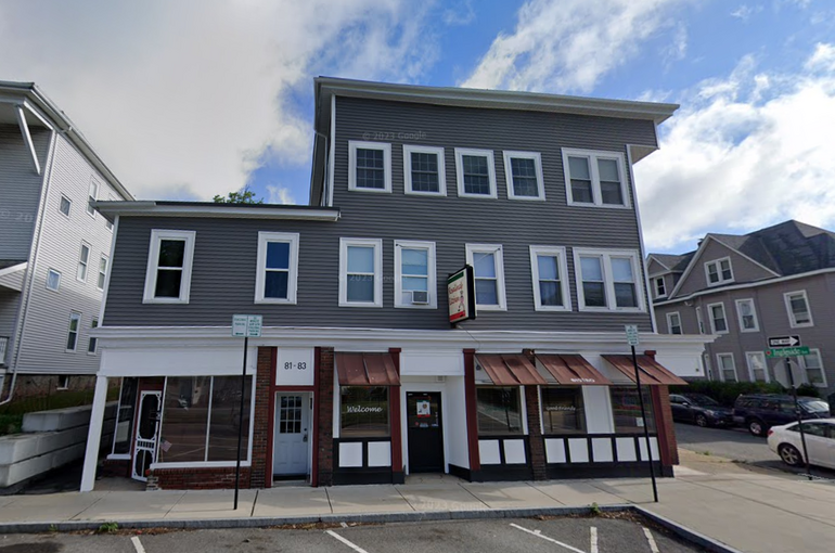 A three-story mixed-use building with a restaurant below and residences above