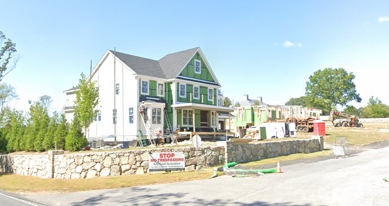 A home under construction with a NO TRESPASSING sign out front