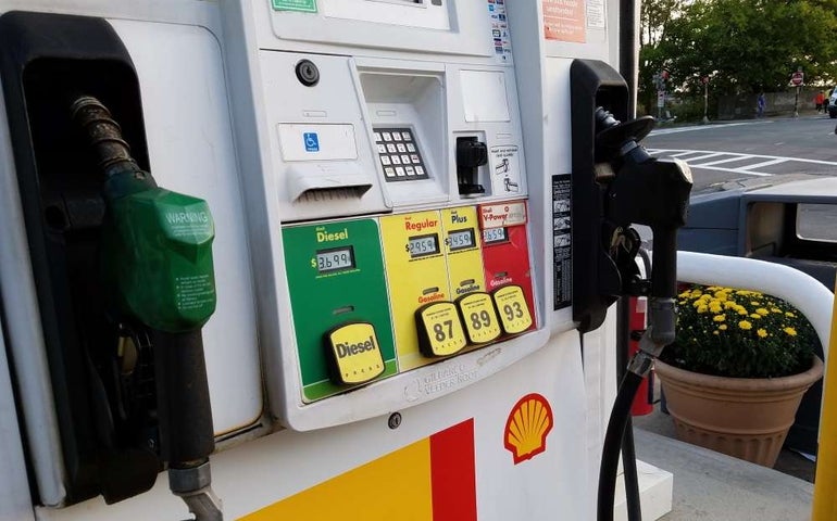 A gasoline pump showing diesel, regular, plus, and v-power prices with handle pumps on either side