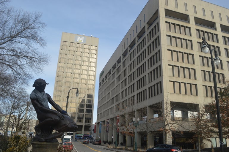 Two office buildings sit behind a statue